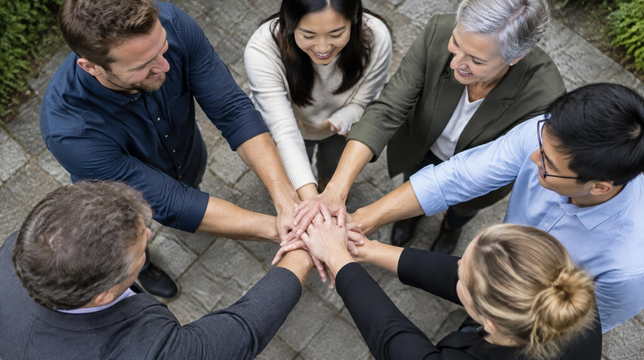 Colleagues stacking hands together as a sign of team spirit